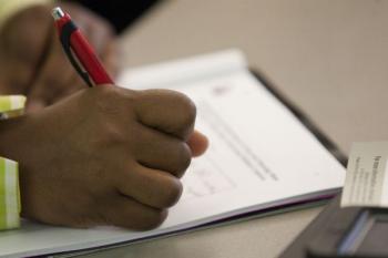 Student writing on paper